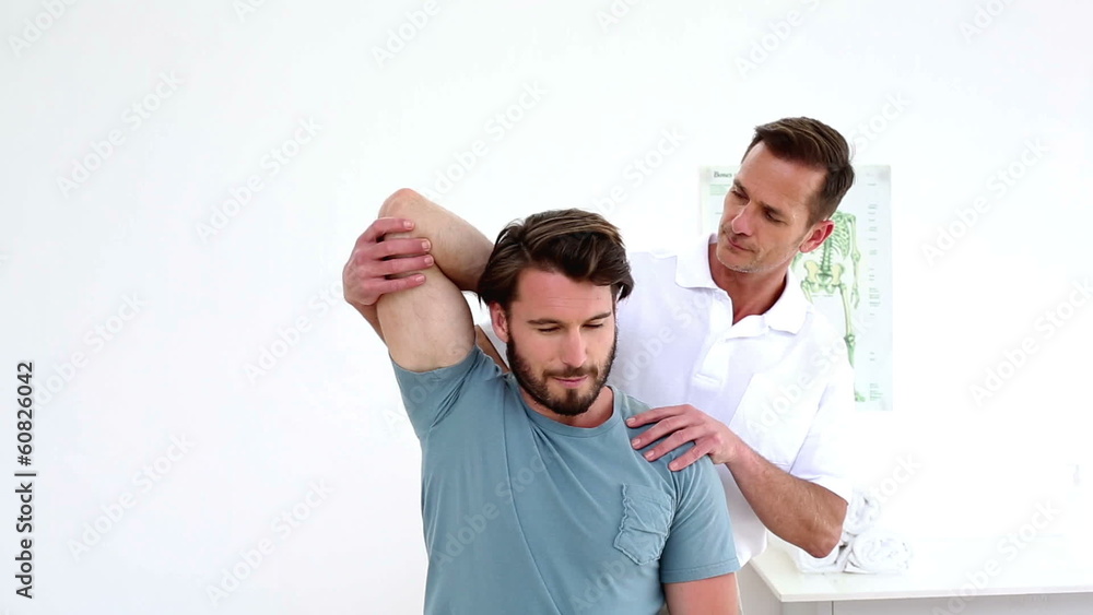 Physiotherapist stretching patients injured shoulder Physiotherapist stretching patients injured shoulder