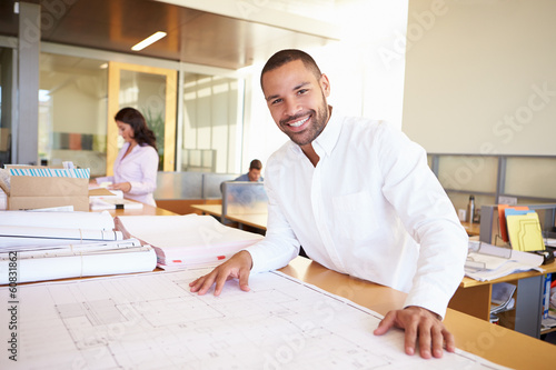 Male Architect Studying Plans In Office