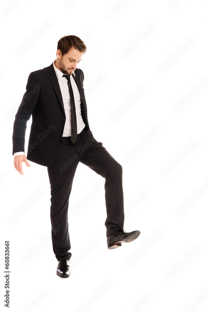 Businessman raising his foot to stamp on something Businessman raising his foot to stamp on something
