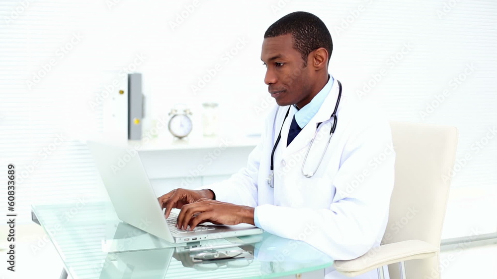 Serious doctor working on his laptop Serious doctor working on his laptop