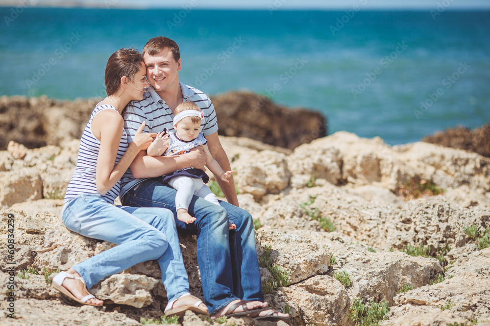 Portrait of a family of three having fun together on the ocean