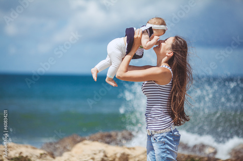 Portrait of happy family mother and baby having fun on the beach