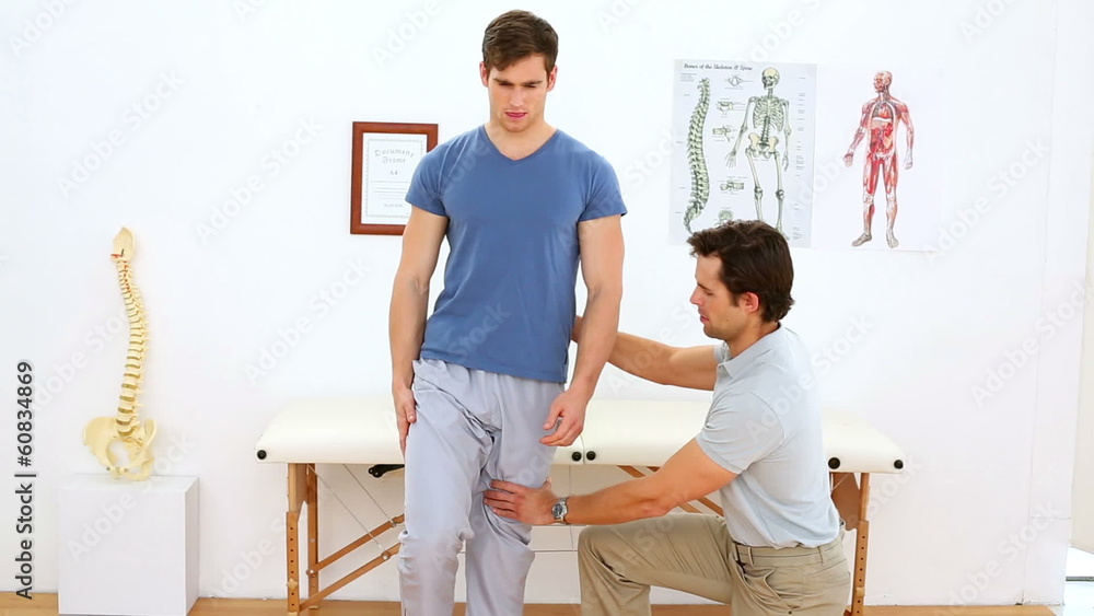 Physiotherapist checking knee of injured patient Physiotherapist checking knee of injured patient
