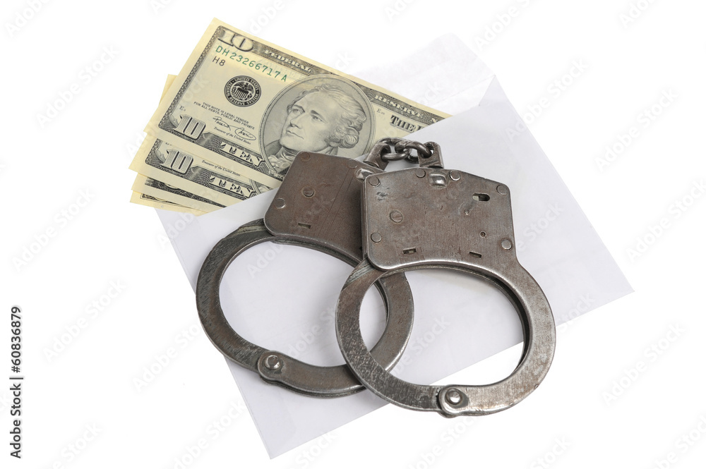 Handcuffs and white envelope with money on white background Handcuffs and white envelope with money on white background
