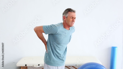 Mature patient rubbing his painful back