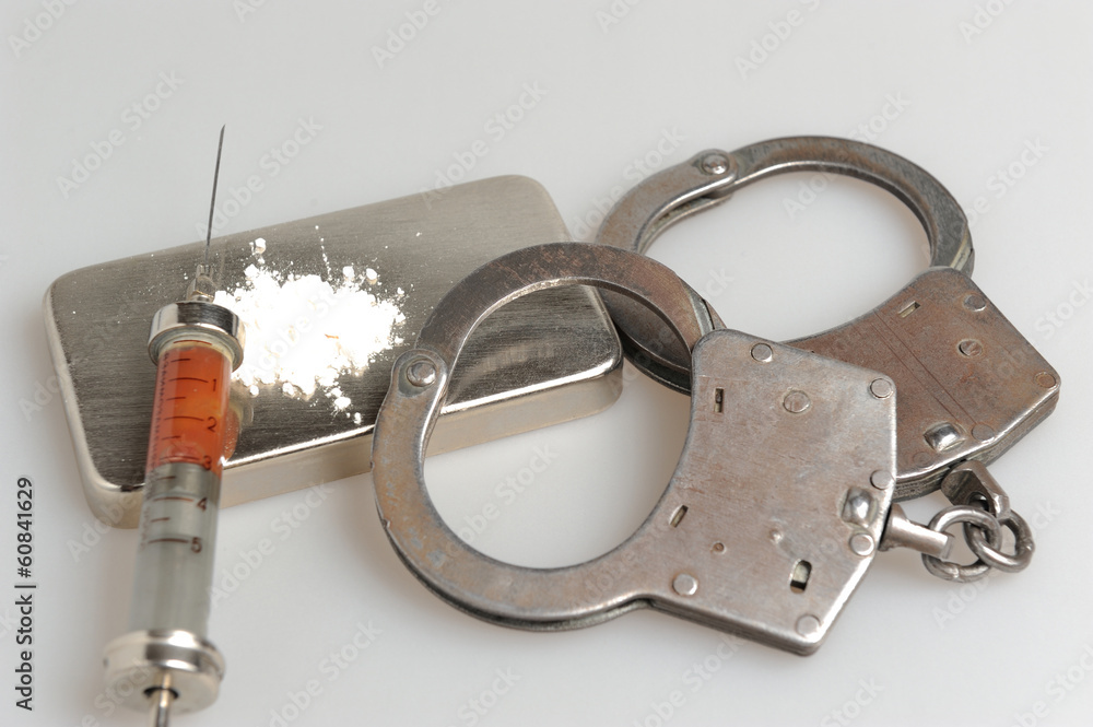 Obraz premium Drugs, syringe with blood, handcuffs on gray