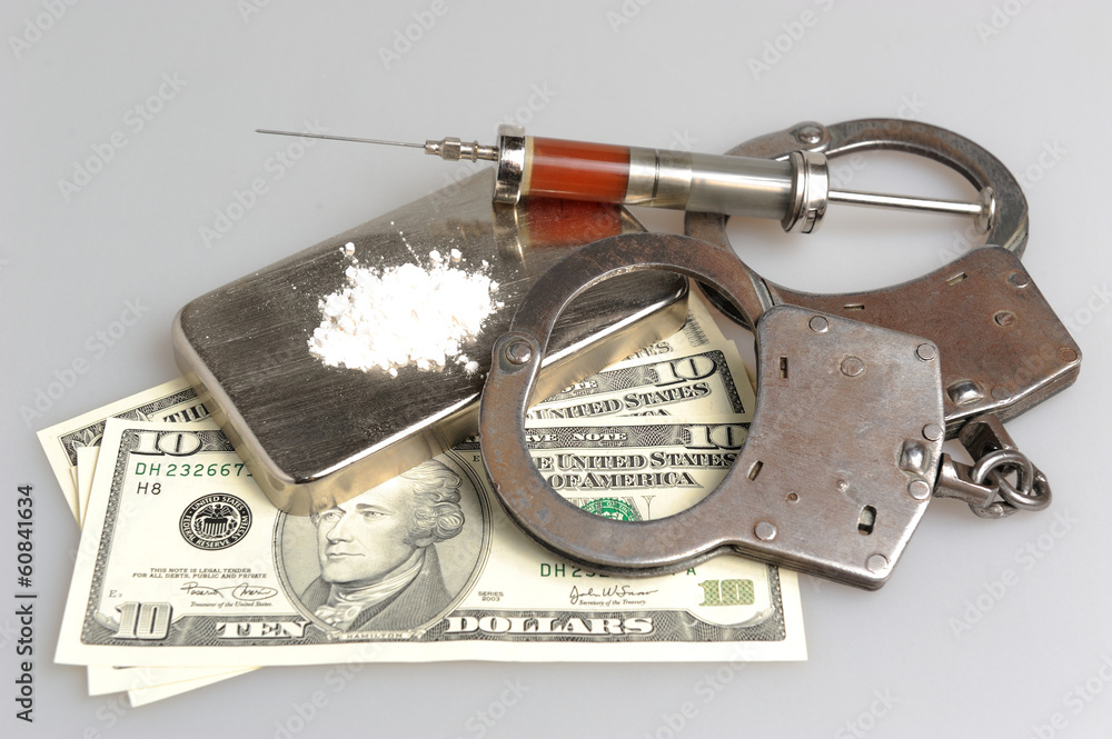 Drugs, syringe with blood, handcuffs and money on gray Drugs, syringe with blood, handcuffs and money on gray