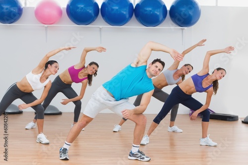 Fototapeta Naklejka Na Ścianę i Meble -  Class doing stretching exercise in fitness studio