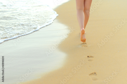 Pair of female legs on a seashore.
