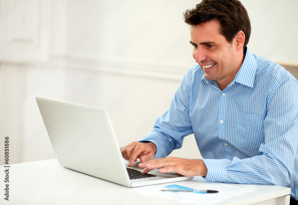 Attractive male entrepreneur working on his laptop Attractive male entrepreneur working on his laptop