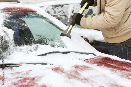 closeup of man scraping ice from car photo