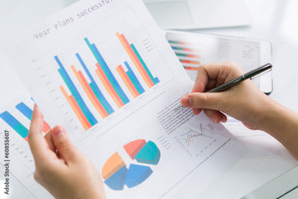 Close-up of business person using digital tablet with financial Close-up of business person using digital tablet with financial