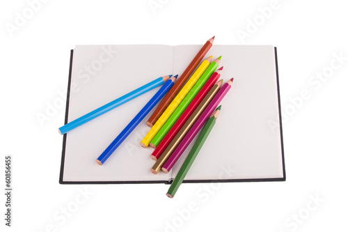 Color pencils placed on notebook, isolated on white