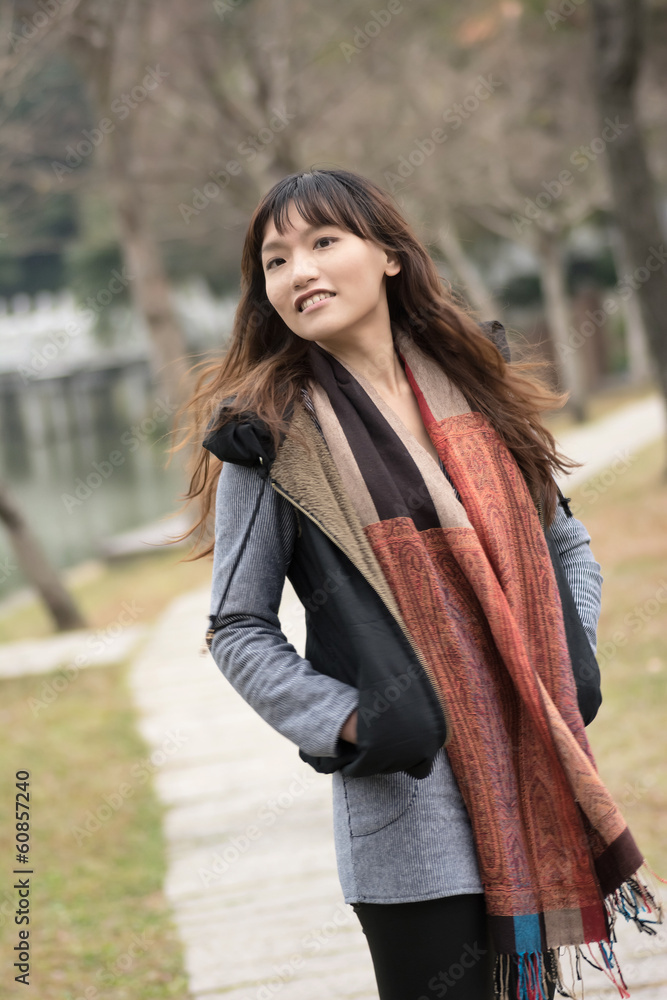 Happy smiling Asian young woman in the park