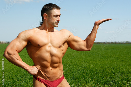 Bodybuilder posing in nature