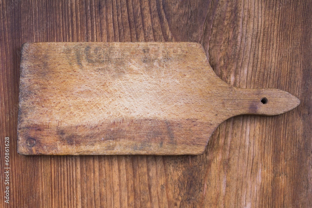 old wooden cutting board on a wooden background