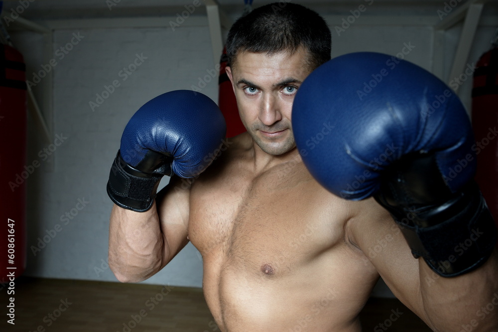 Boxer with gloves on training in the gym Boxer with gloves on training in the gym