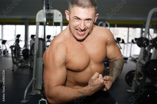 Bodybuilder training in the gym at full power