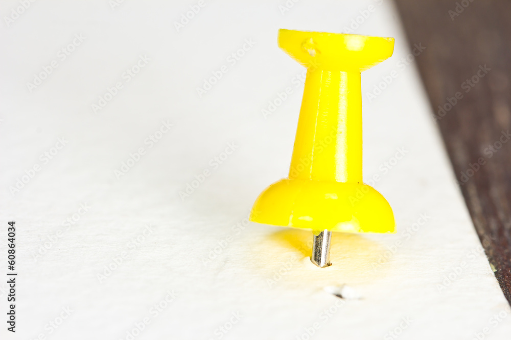Push pin on a white paper Push pin on a white paper