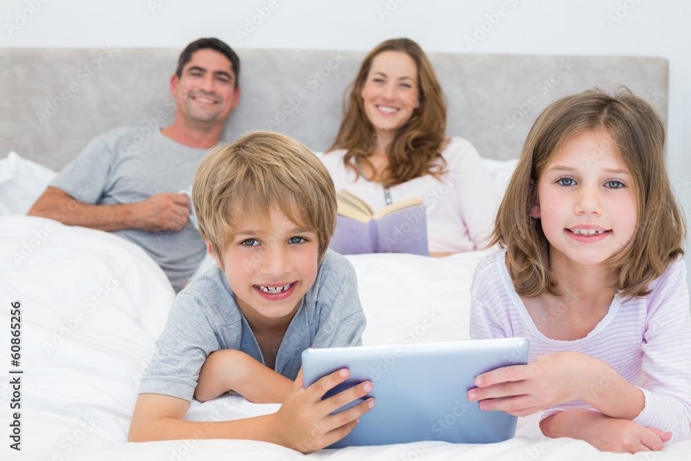 Smiling siblings holding digital tablet Smiling siblings holding digital tablet