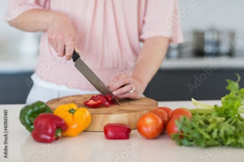 Mid section of woman chopping vegetables