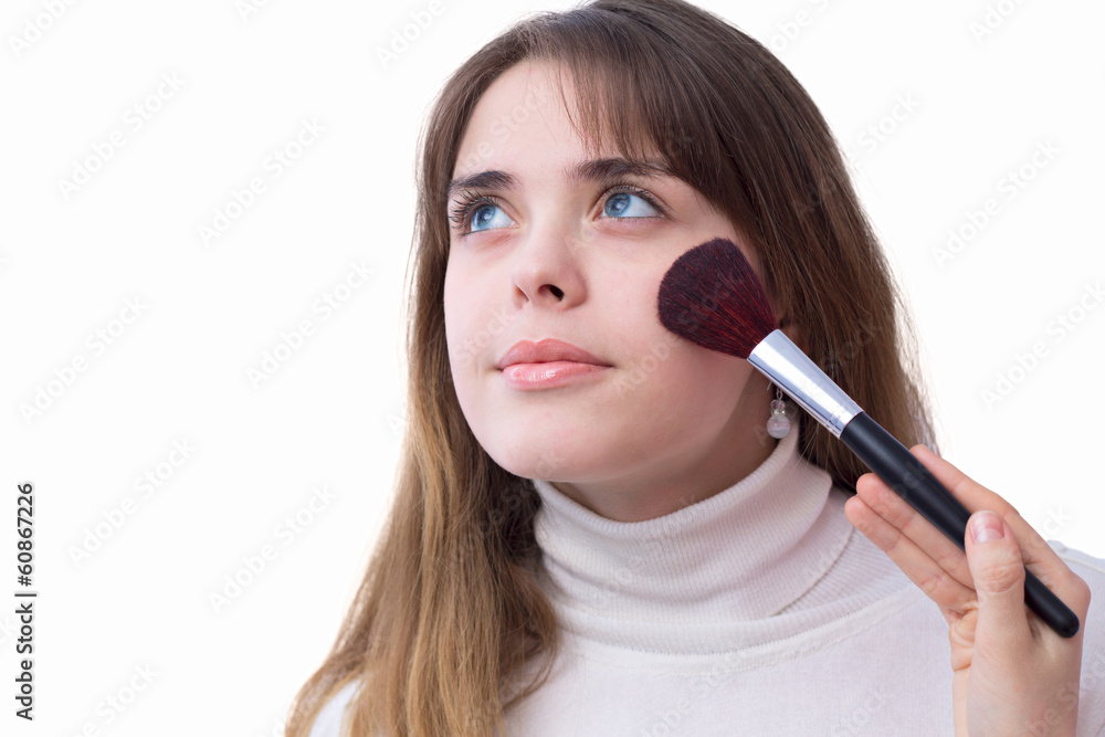 portrait of a girl with a brush for makeup near her face portrait of a girl with a brush for makeup near her face