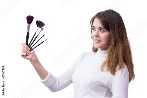 beautiful girl with a set of brushes for makeup in her hands