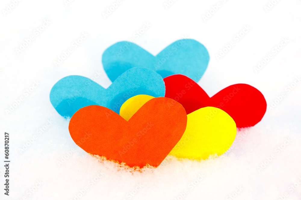 Five paper colored heart shapes in snow Five paper colored heart shapes in snow