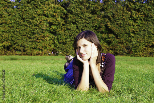 young woman laying on green grass