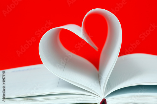 Heart shape of diary pages on a red background