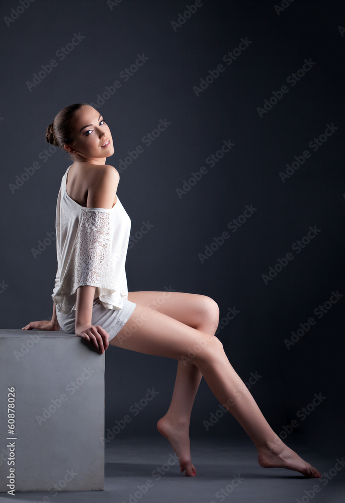 Attractive young model posing sitting on cube Attractive young model posing sitting on cube