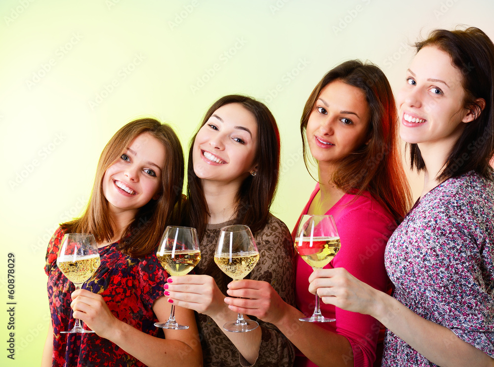 Happy young women friends touching the glasses with each other o Happy young women friends touching the glasses with each other o