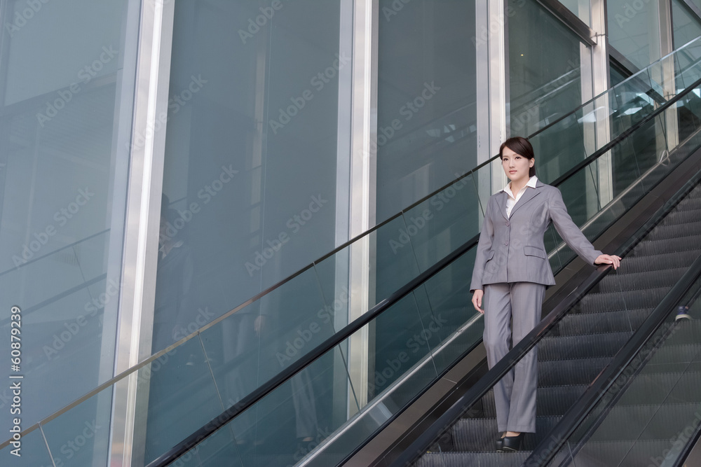 Asian business woman stand at escalator Asian business woman stand at escalator