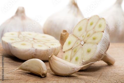 Photography Bulbs of fresh garlic with several cloves on the cutting board.