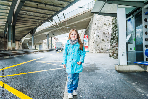 Outddor portrait of a cute little girl on a bus station