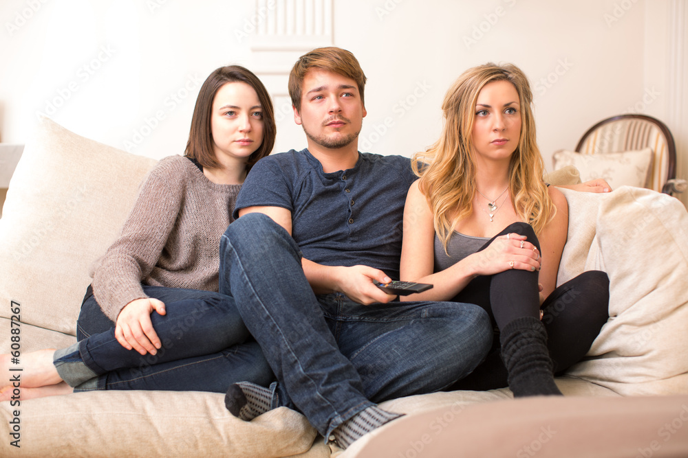 Fascinated teenagers sitting watching television Fascinated teenagers sitting watching television