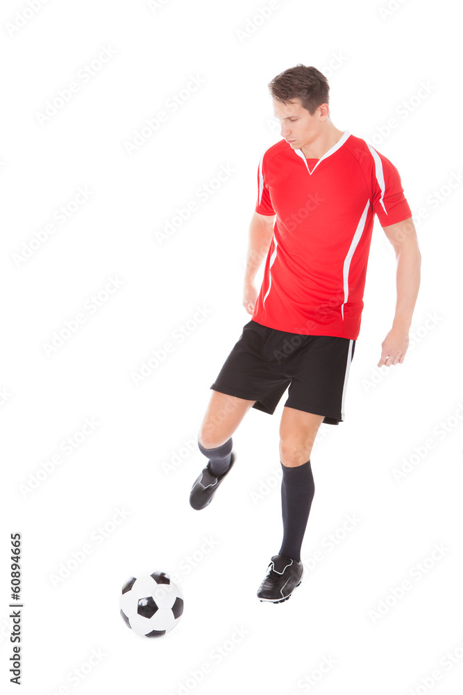Young Male Soccer Player Kicking Football