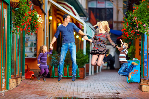 happy family jumping on colorful street