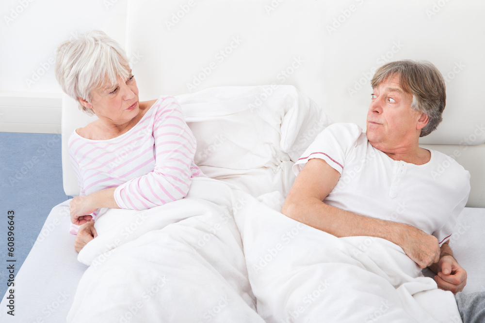 Angry Couple Lying On Bed