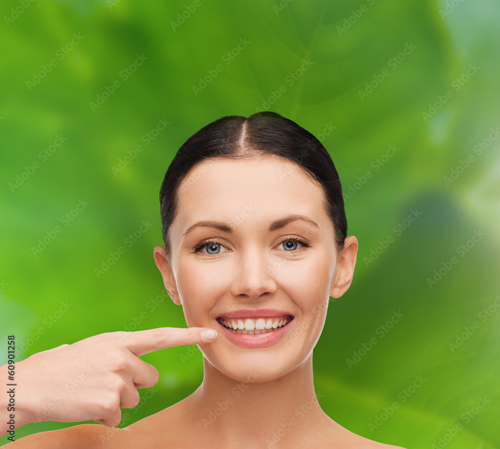 young calm woman pointing to her mouth young calm woman pointing to her mouth