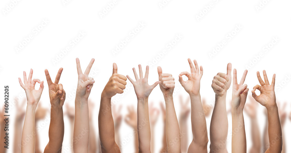 human hands showing thumbs up, ok and peace signs