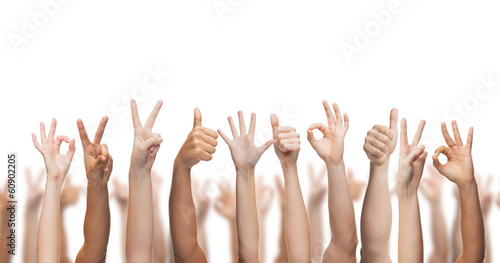 human hands showing thumbs up, ok and peace signs