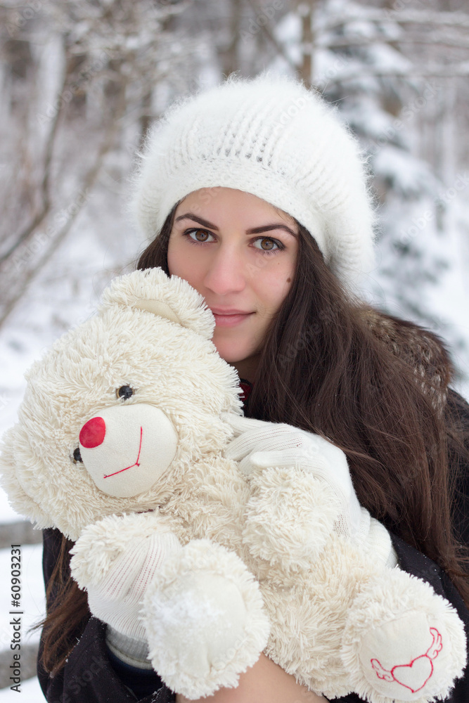 Cheerful Caucasian Young Woman in Snowy Weather holds a toy Cheerful Caucasian Young Woman in Snowy Weather holds a toy