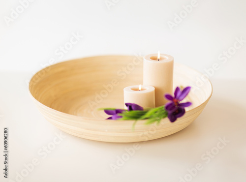 candles and iris flowers in wooden bowel