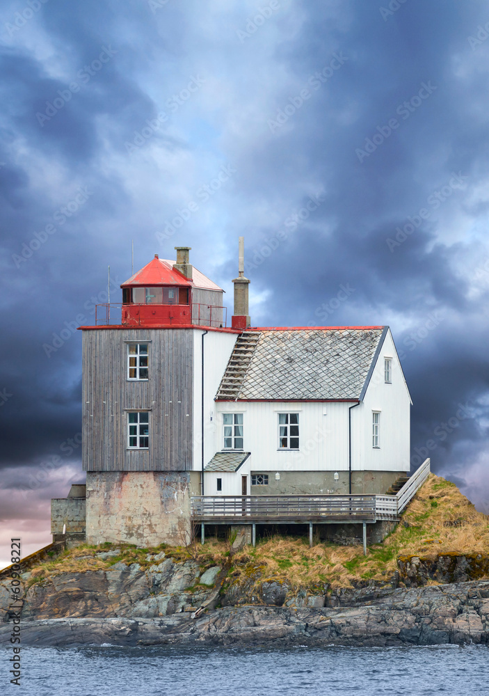 Fototapeta premium Old Norwegian lighthouse on rocky island with dramatic sky