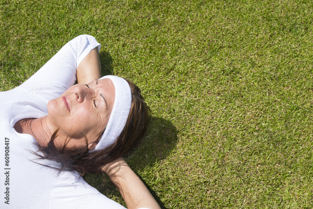 Senior woman resting relaxed on lawn Senior woman resting relaxed on lawn