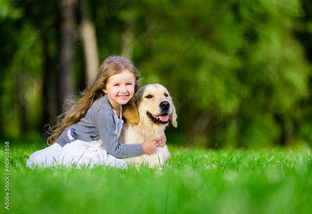Little girl sitting on the grass with golden retriever Stock Photo ...