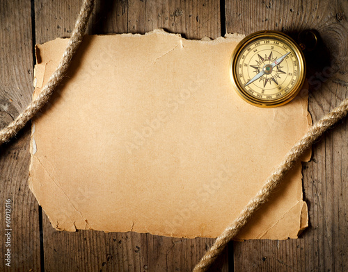 Foto Old compass and rope on old paper.