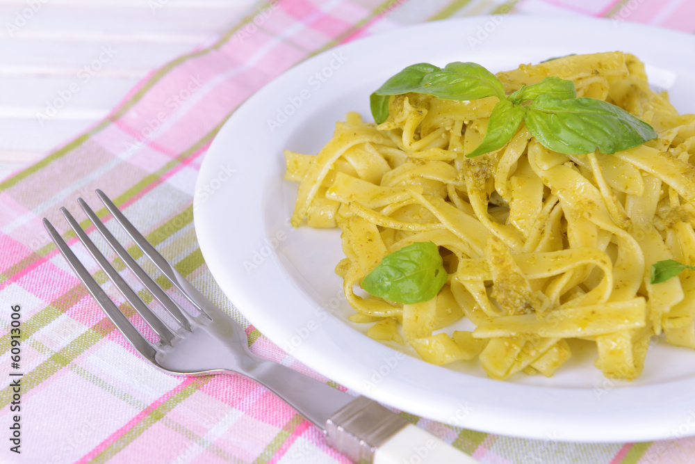 Delicious pasta with pesto on plate on table close-up Delicious pasta with pesto on plate on table close-up