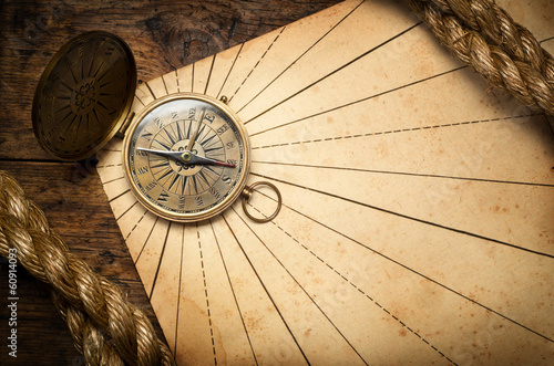 Old compass and rope on vintage paper.